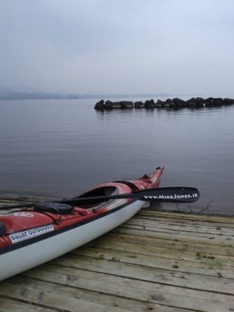 A kayak resting quietly on a jetty at dusk